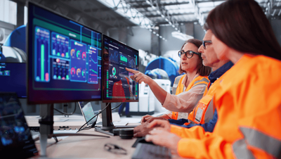 Engineers in front of a computer discussing process thinking